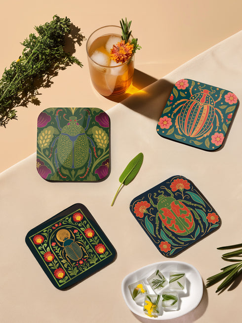 Set of 4 square Dark Academia Scarab Beetle Coasters, featuring detailed Gothic Botanical insect art prints in deep jewel tones. The hardboard coasters have a glossy finish and protective cork base. Premium Entomology Decor.